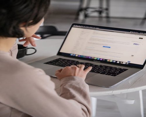 Person typing on laptop with proper posture and screen distance
